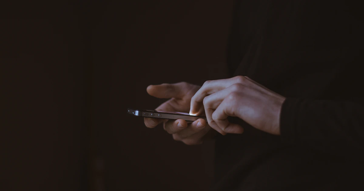 Voyageur écrivant un message sur son téléphone en soirée
